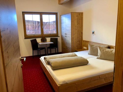 索尔登桑特霍夫公寓式酒店的一间卧室配有一张床和一张桌子及椅子