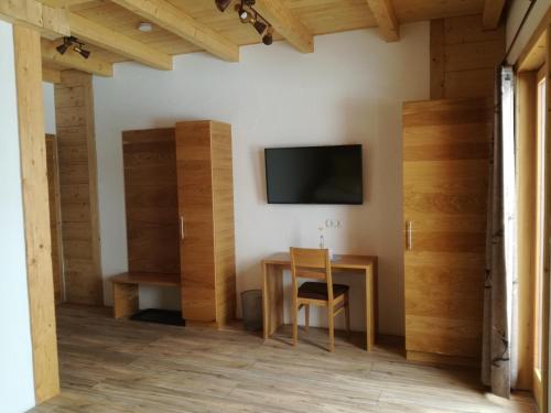 StockenboiWieser Hütte的一间设有桌子的房间和墙上的电视