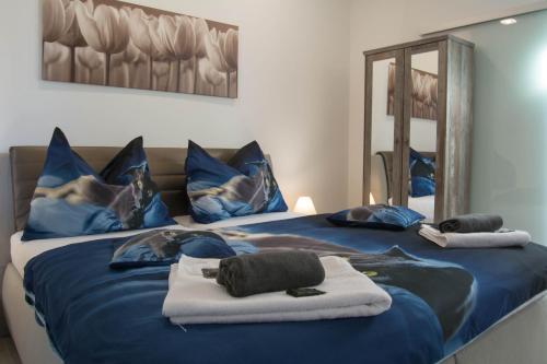 VřesinaApartments Gerda的一间卧室配有两张带蓝色床单和镜子的床