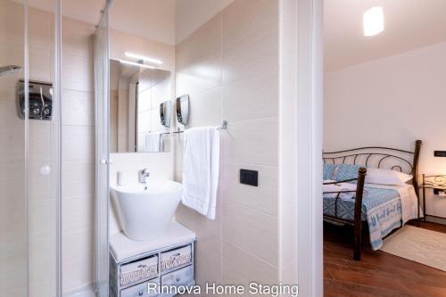 卡波泰拉Villa Vitto - Sleep & Go的一间带水槽和淋浴的浴室以及一张床