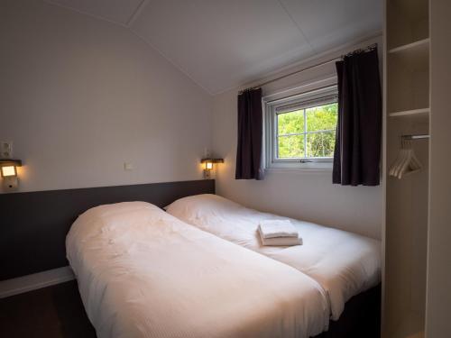 哈林亨Luxe Lodge Zeehoeve的卧室配有一张大白色床和窗户