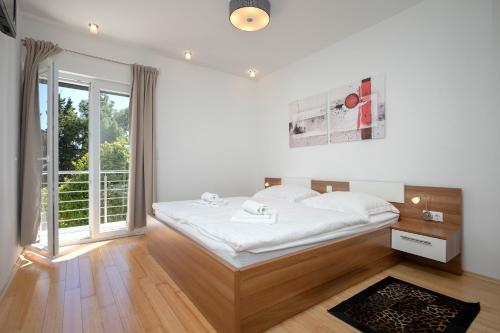 赫瓦尔维露公寓的卧室设有白色的床和大窗户