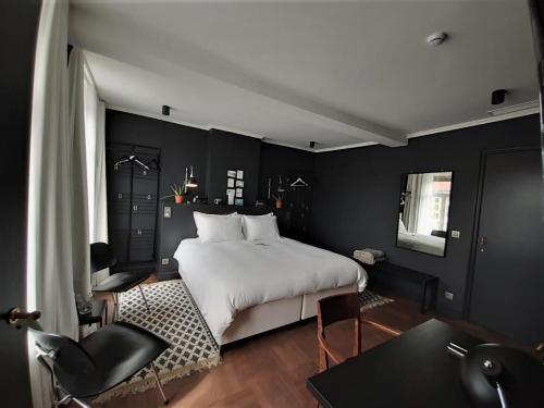 科特赖克Broel4的卧室配有白色的床和黑色的墙壁