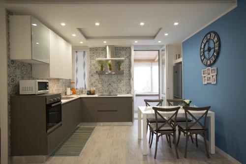 费尔蒂利亚Appartamento Roberto House的厨房配有桌椅和蓝色的墙壁