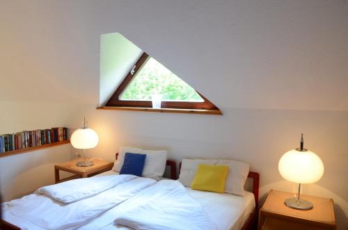 布莱德Architect’s house - peaceful and minimalistic的一间卧室配有一张带两盏灯的床和一扇窗户。