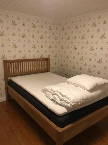 KisaYxefall Norrgården的卧室内的一张床铺,墙上挂着鲜花