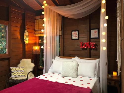 因比图巴Cabana Encantos da Lagoa的一间卧室配有一张带天蓬的白色床