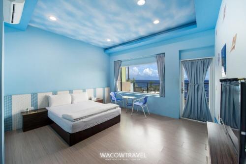 小琉球岛夏之嶼海景包棟民宿的一间卧室设有一张床和一个大窗户
