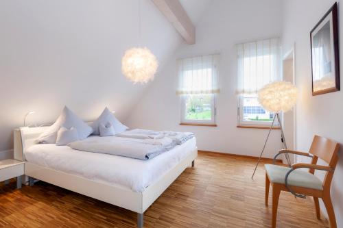 哈格瑙哈诺儿斯珀勒酒店的白色卧室配有床和椅子