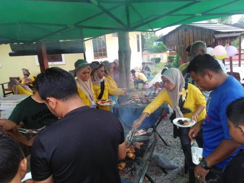 哥打巴鲁Challet Chengal的一群人站在烧烤炉旁,一边吃着食物