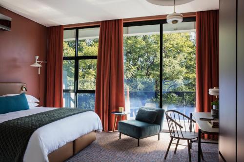 约翰内斯堡Home Suite Hotels Rosebank的一间卧室配有一张床、一把椅子和一张书桌