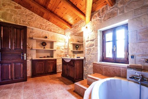 Ágios NikólaosThe Vivian - Luxury Stone Villa的带浴缸和窗户的大浴室