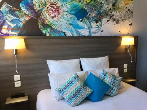 塔布林荫道酒店的一间卧室配有带枕头的床铺和绘画