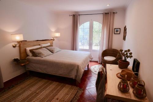费雷列斯La Casa Menorca的一间卧室设有一张床、一个窗口和一张桌子