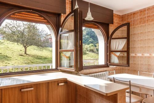 Porrúa艾尔坡拉伊格莱西亚乡村民宿的厨房设有2个大窗户和桌子