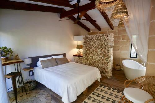 费雷列斯La Casa Menorca的一间卧室配有一张床,浴室设有浴缸