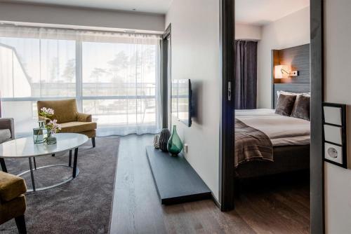 巴斯塔德Hotel Riviera Strand的一间卧室配有一张床、一张桌子和一张沙发