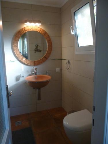 阿里拉斯Athina Apartments的一间带水槽、镜子和卫生间的浴室