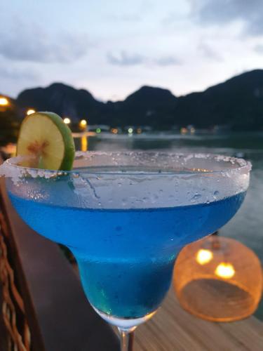 皮皮岛Phi Phi Green House & Sunsky Hostel的桌子上边的淡蓝色饮料和石灰