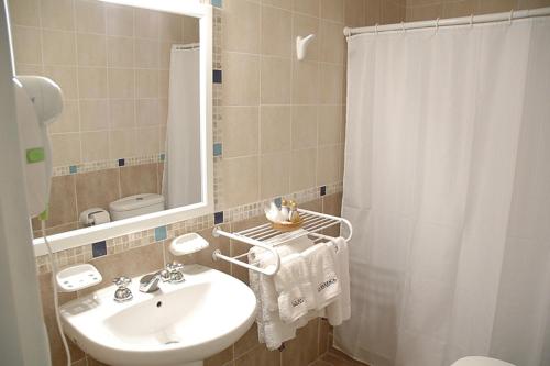 梅洛La Barraca Resort的一间带水槽和淋浴帘的浴室