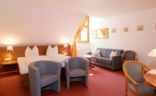 波茨坦凯瑟琳霍尔兹酒店的酒店客房,配有一张床和两把椅子