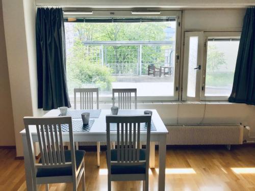赫尔辛基Kamppi City Apartment的一间带桌椅和窗户的用餐室