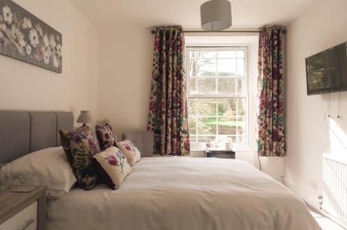 赫尔斯顿斯特拉撒伦旅馆的一间卧室配有床和带窗帘的窗户