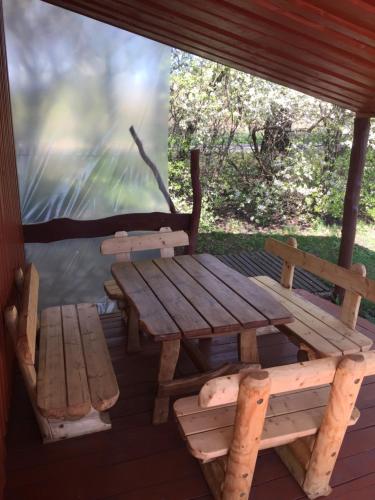 普拉特利艾Antano Razgaus kaimo turizmo sodyba的木餐桌和门廊上的长凳