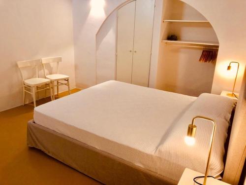马蒂诺Palazzo Boccaccio的一间卧室配有一张大床和两把椅子