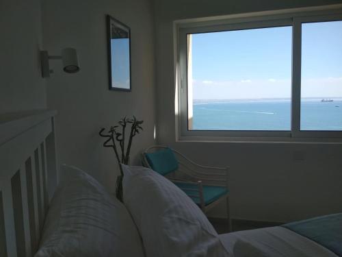 拉纳卡Luxury Penthouse 1BR-Seafront-Seasonal Pool-Central的一间卧室配有一张床,享有海景