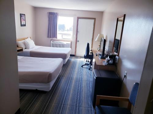 萨斯卡通Travel-Inn Resort & Campground的酒店客房设有两张床和电视。