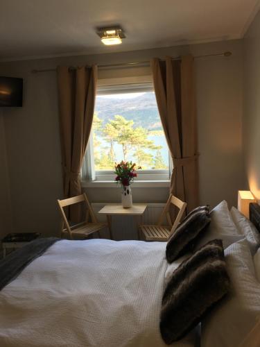洛哈尔什教区凯尔高地Lochalsh View, Kyle, 1 Mile to Skye的一间卧室配有一张带窗户和桌子的床