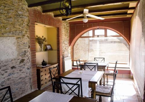 San Pedro del ValleCasa Rural La Torrecilla的餐厅设有桌椅和大窗户。