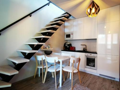 派尔努Kuninga 24 Apartment的厨房设有餐桌和楼梯。