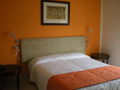奥莱焦马尔彭萨埃尔酒店的一间卧室配有一张橙色墙壁的床