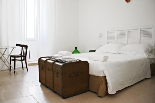 特拉尼La Mitria的一间卧室配有一张带行李箱的大床