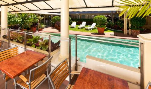 凯恩斯凯恩斯皇庭酒店的阳台设有游泳池和桌椅。