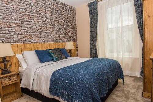 圣奥斯特尔Deluxe Rustic Charlestown Themed Apartment的一间卧室设有一张带砖墙的大床