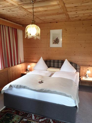 Höfen埃斯侯阿马特酒店的一间卧室配有一张带吊灯的大床