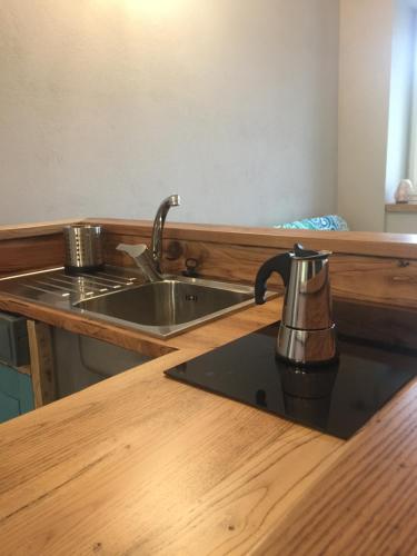 Santa Maria RoccaHappy hill -appartamento Quercia的厨房柜台配有水槽和茶壶