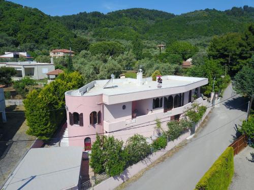 AchladiVilla Ioanneta的山前有树木的粉红色房子