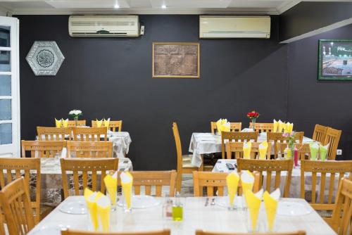 马普托Taka-Taka的用餐室配有桌椅和黄色弓