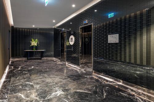 墨尔本马尔科想象公寓的浴室铺有黑色瓷砖墙壁和大理石地板。