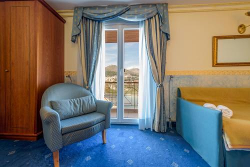 卡斯托里亚Hotel Kastoria in Kastoria City的一间卧室配有椅子、床和窗户