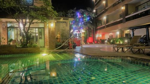 乔木提恩海滩Aiyaree Place Hotel SHA PLUS的游泳池在晚上设有喷泉
