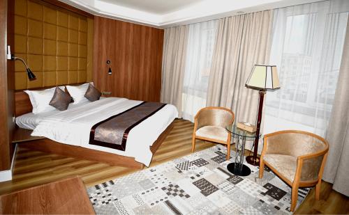 乌兰巴托普玛帝国酒店的卧室配有一张床和一张桌子及椅子