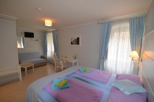 大洛希尼Hotel Villa Elisabeth - Veli Lošinj Health Resort的一间带大床的卧室和一间客厅