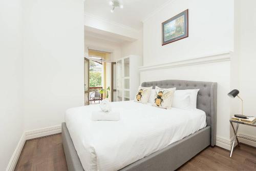 悉尼STUNNING SYDNEY HOME 4的白色的卧室设有一张大床和一个窗户