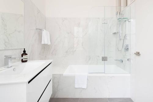 悉尼STUNNING SYDNEY HOME 4的带淋浴和盥洗盆的白色浴室