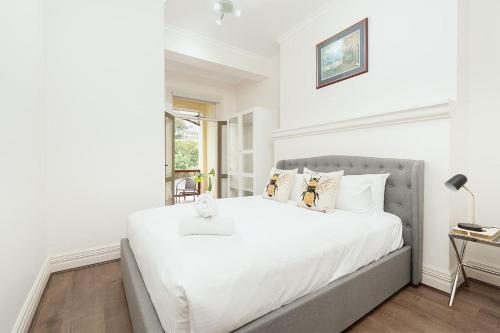 悉尼STUNNING SYDNEY HOME 10的白色的卧室设有一张大床和一个窗户